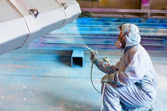 Industrial Painter painting a metal piece